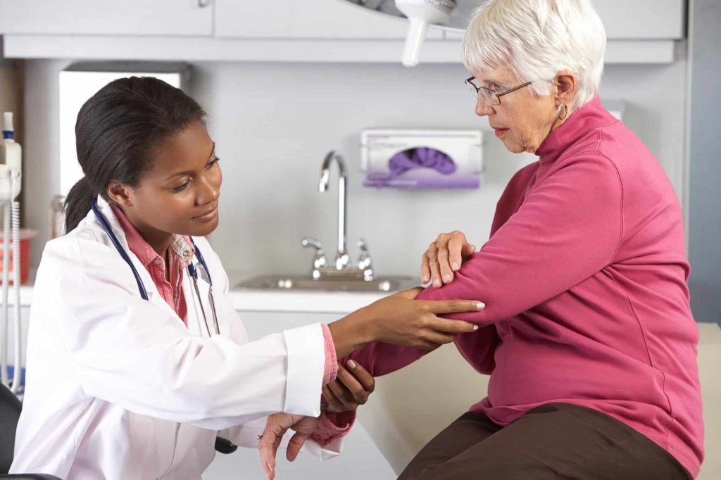 Doctor examining a female patient for pain management at MidSouth Pain Treatment Center in Miramar, Hollywood, and Lauderdale Lakes FL.